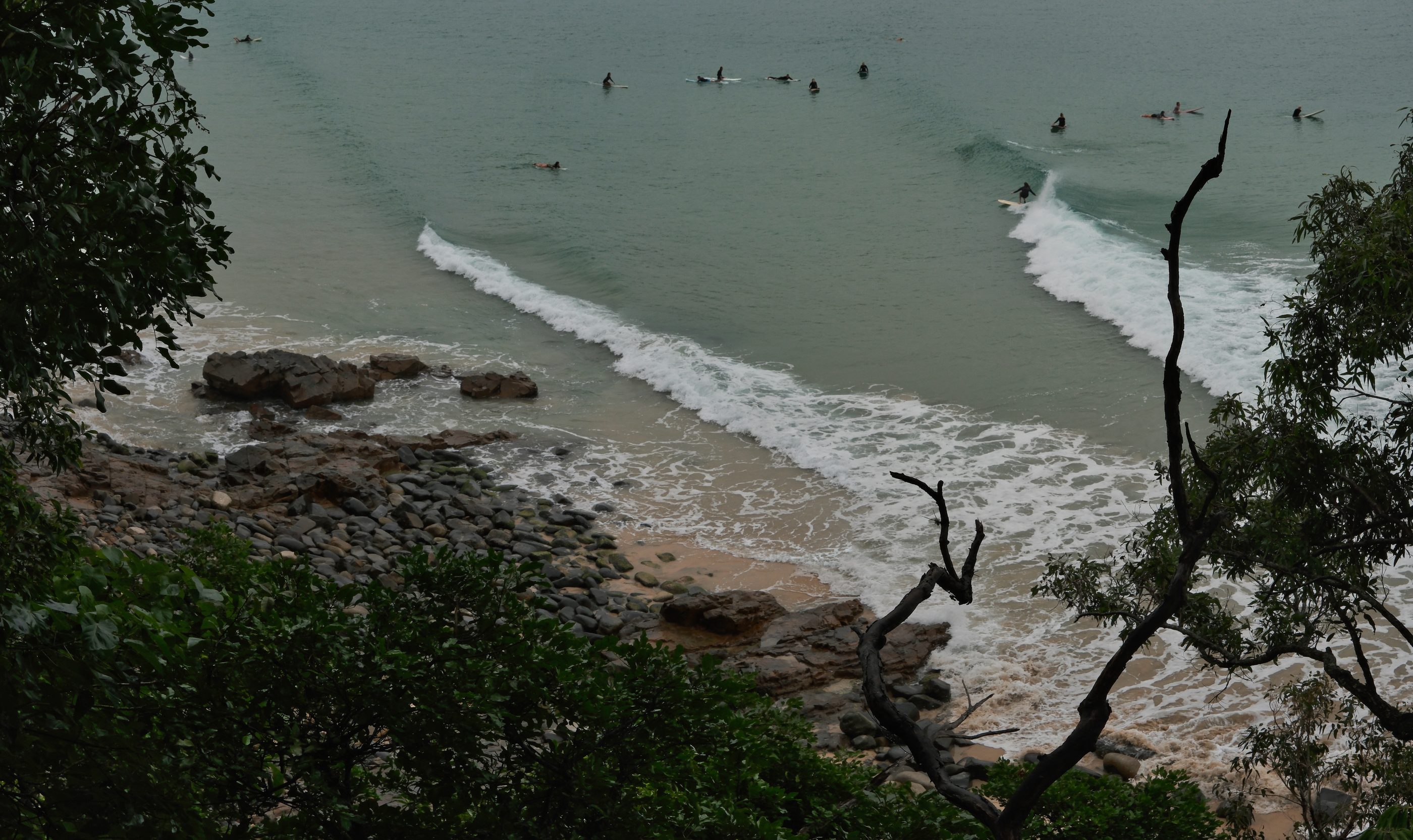 Looking down from the headland at surfers in the cove