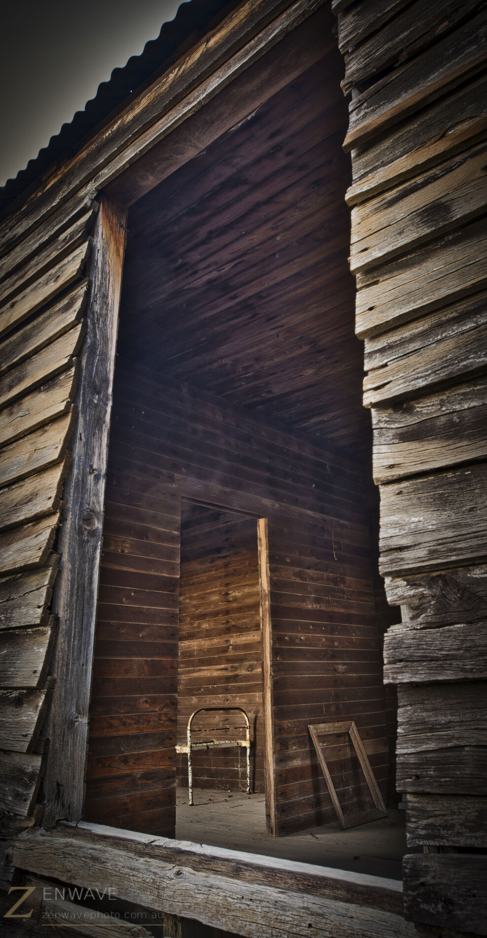 Looking in through the cabin doorway — suitcase and bed frame still inside