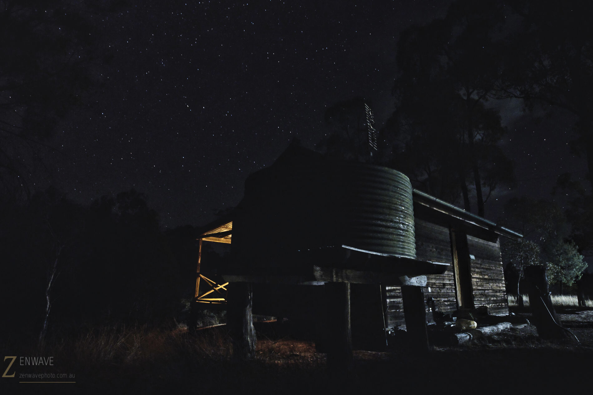 Water tank lit at night beside the cabin